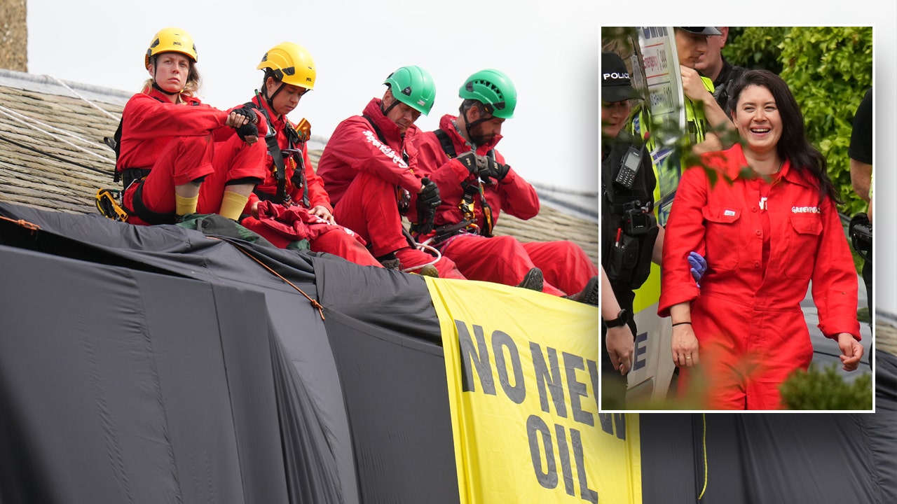 Greenpeace climate protesters climb atop UK prime minister’s home, hang black fabric